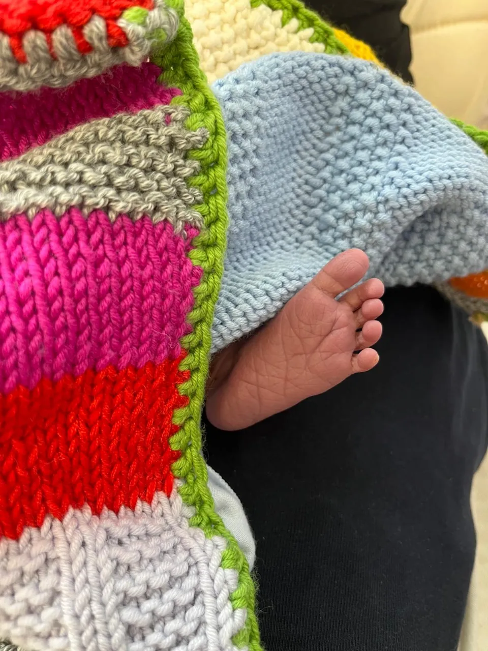 Il piedino di un neonato su una coperta fatta all'uncinetto